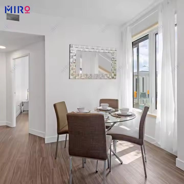 Elegant rectangular wall mirror with a mosaic-style mirrored tile frame displayed above a round dinning table- Fabels
